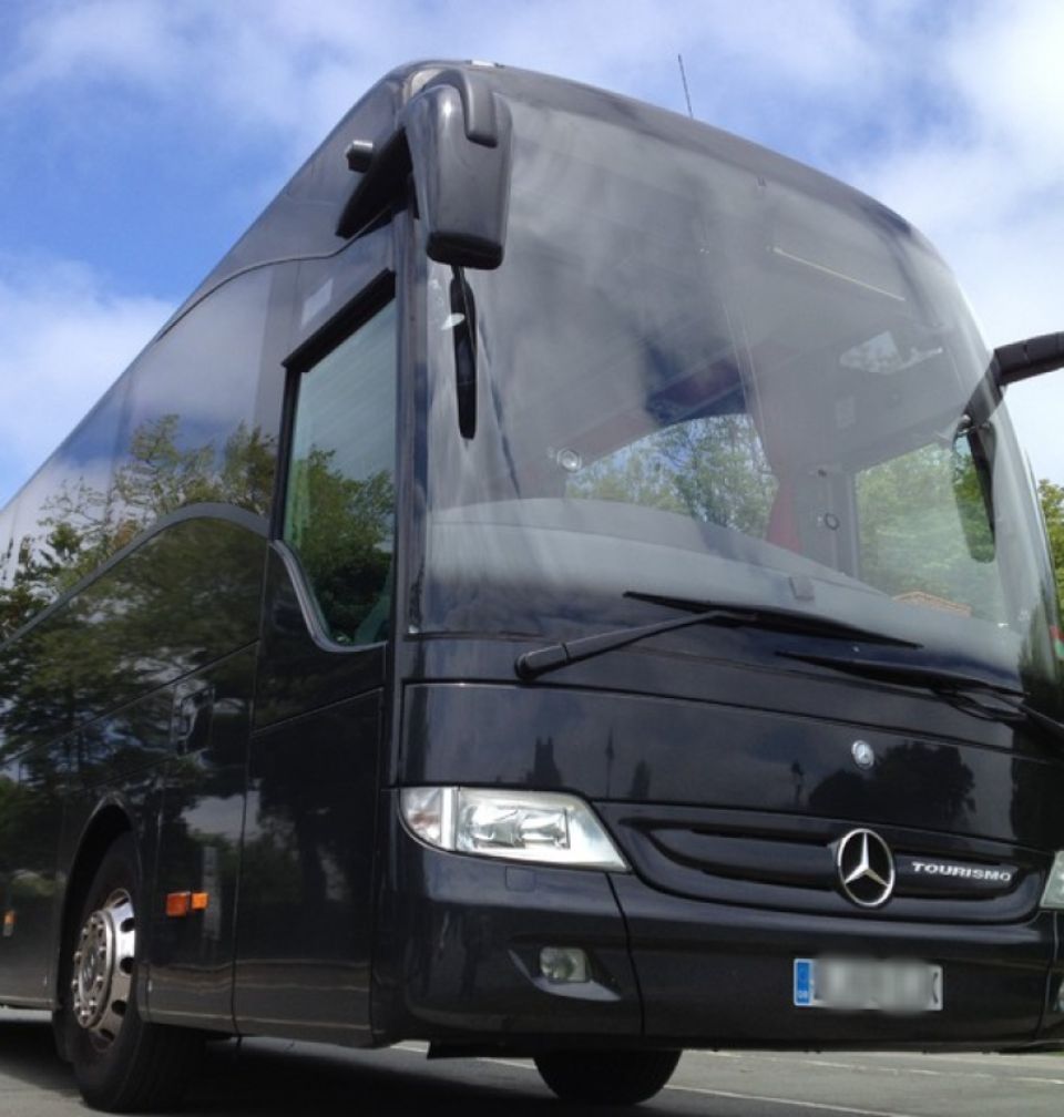 Black tour bus under blue sky